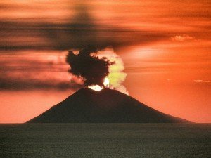 Il sole che tramonta dietro il cratere dello Stromboli Tramonto del sole dietro il cratere dello Stromboli in eruzione